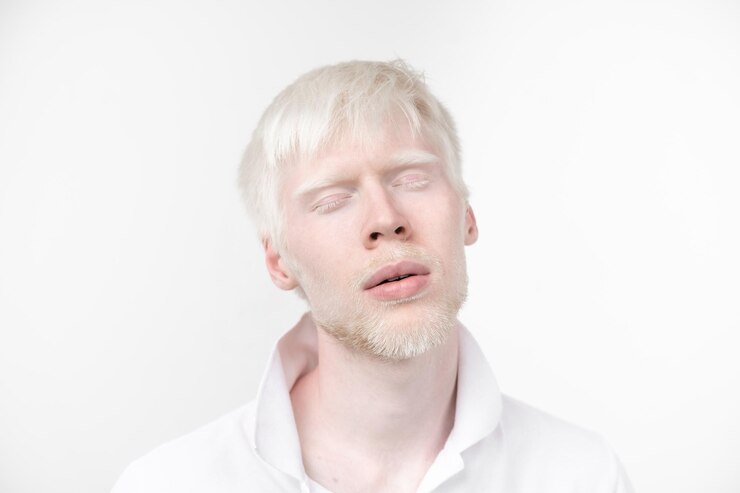 Foto close-up de um homem com os olhos fechados de pé contra um fundo branco