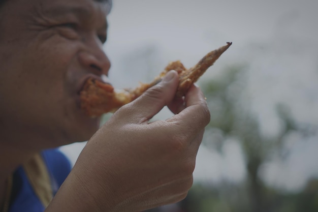 Foto close-up de um homem comendo comida ao ar livre
