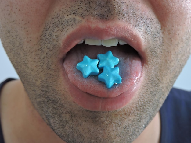 Foto close-up de um homem comendo doces azuis