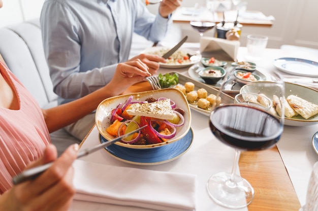 Close-up de um homem e uma mulher sentados à mesa e comendo comida deliciosa no café