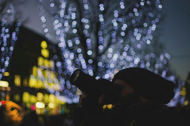 Foto close-up de um homem fotografando à noite durante o natal