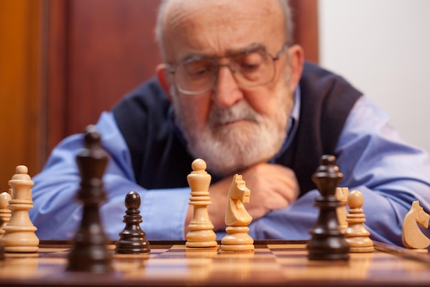 Close-up de um homem idoso jogando xadrez