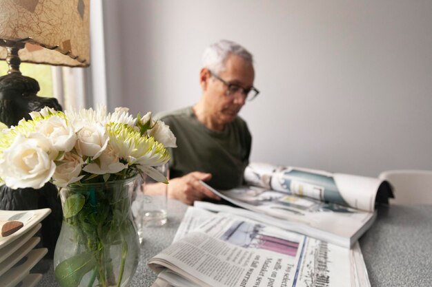 Foto close-up de um homem idoso lendo livros enquanto está sentado na mesa em casa