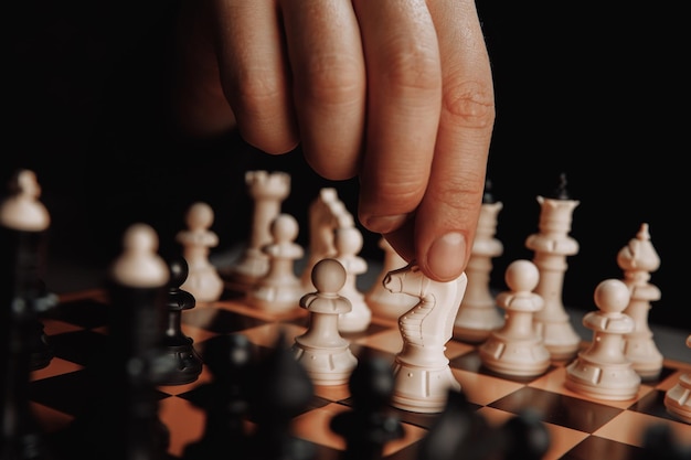 Close-up de um homem jogando xadrez em um tabuleiro de xadrez.