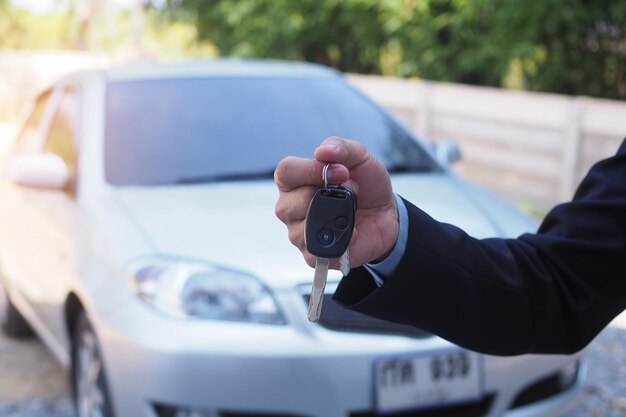 Close-up de um homem segurando a chave contra o carro