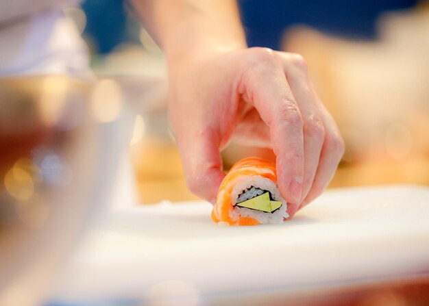 Foto close-up de um homem segurando sushi