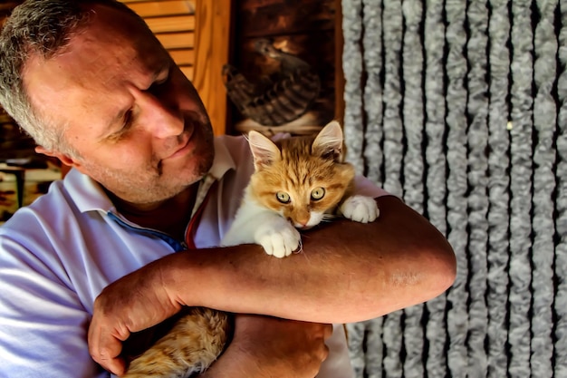 Foto close-up de um homem segurando um gato em casa