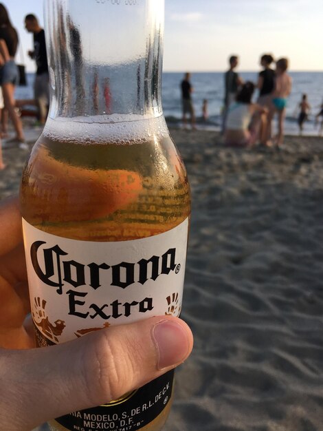 Close-up de um homem segurando uma garrafa de cerveja