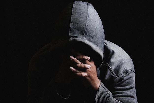 Close-up de um homem triste contra um fundo preto