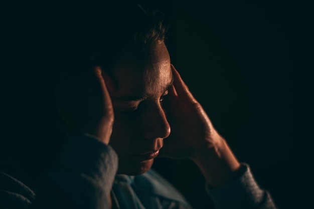 Close-up de um homem triste contra um fundo preto