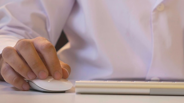 Close-up de um homem usando computador sua camisa e gravata no fundo