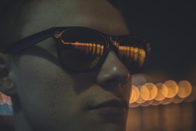 Foto close-up de um homem usando óculos de sol à noite
