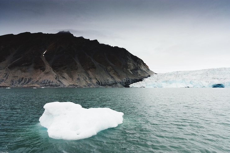 Foto close-up de um iceberg em um lago contra uma montanha