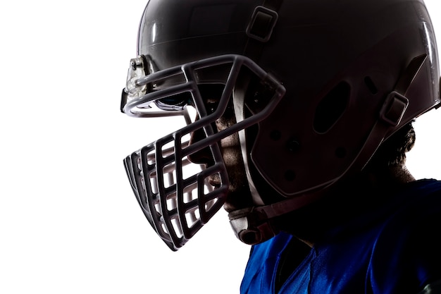 Close-up de um jogador de futebol com um uniforme azul em uma parede branca