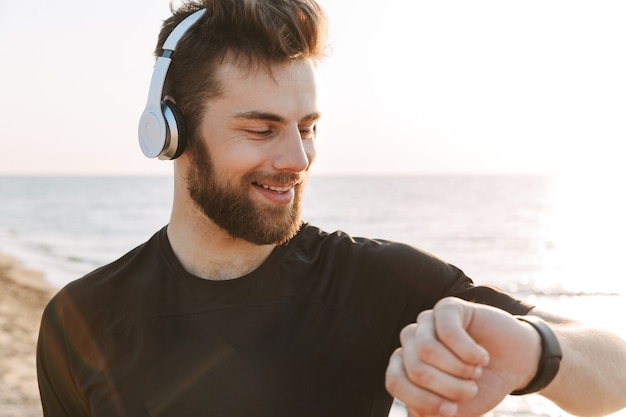 Close-up de um jovem desportista bonito em fones de ouvido