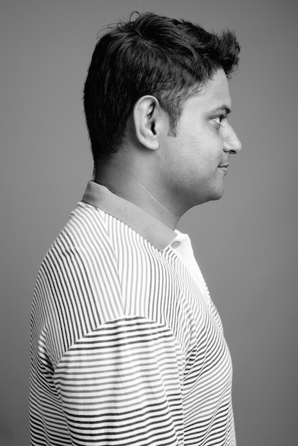 Close-up de um jovem indiano vestindo uma camisa pólo listrada de manga comprida