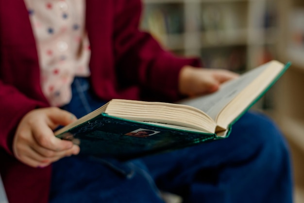 Close-up de um livro aberto nas mãos de uma criança