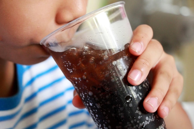 Foto close-up de um menino bebendo suco