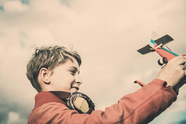 Close-up de um menino brincando com um avião de brinquedo