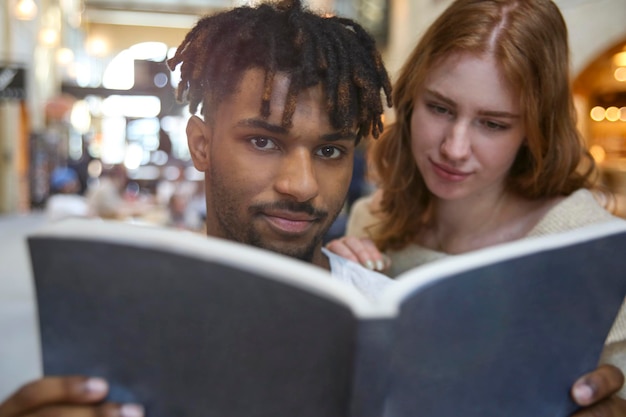 Foto close-up de um menino e uma mulher lendo um livro