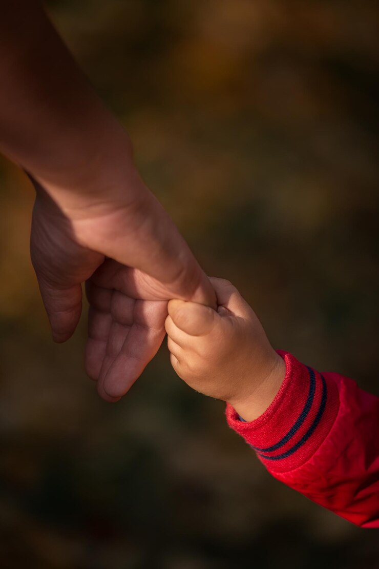 Foto close-up de um menino segurando a mão da mãe