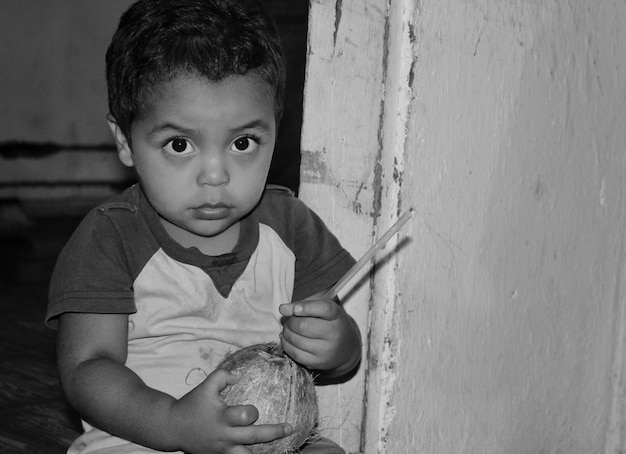 Foto close-up de um menino segurando um coco em casa