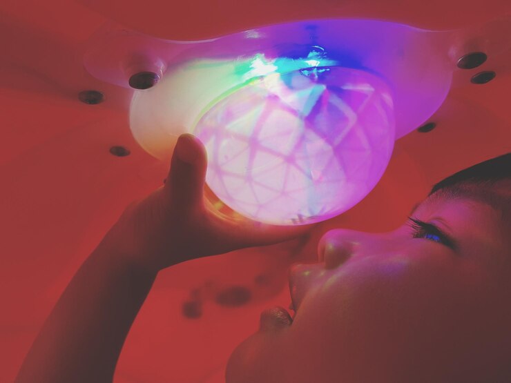 Foto close-up de um menino segurando uma luz iluminada