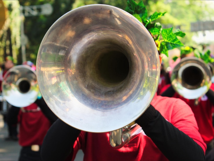 Foto close-up de um menino tocando trompete com reflexo