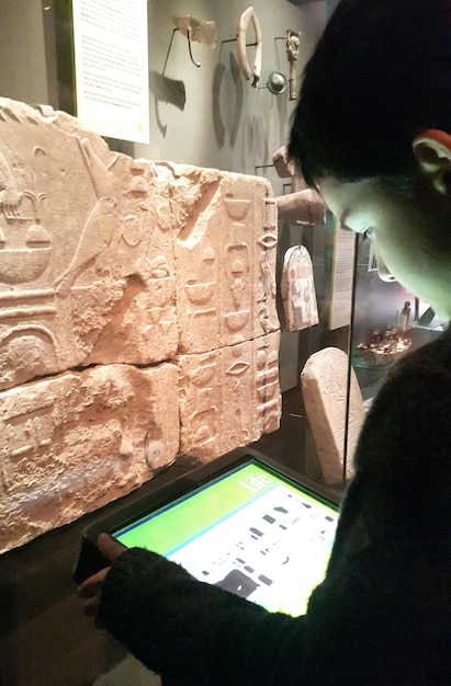 Foto close-up de um menino usando um tablet digital no museu