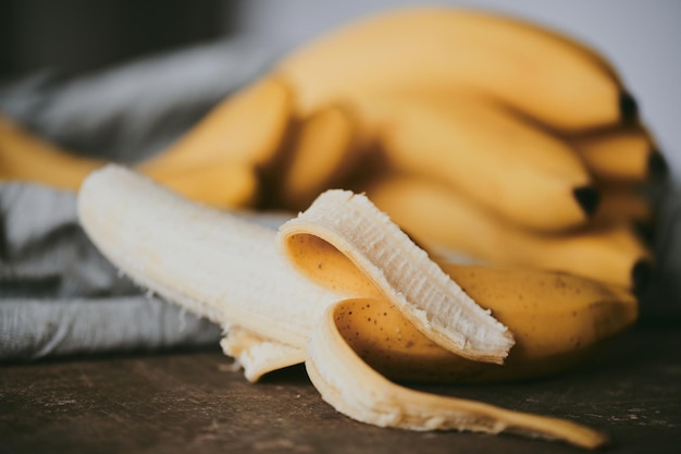 Foto close-up de um monte de bananas em um fundo de tecido escuro