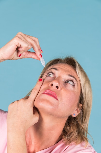 Foto close-up, de, um, mulher, gotejando, médico, gotas, em, dela, olho