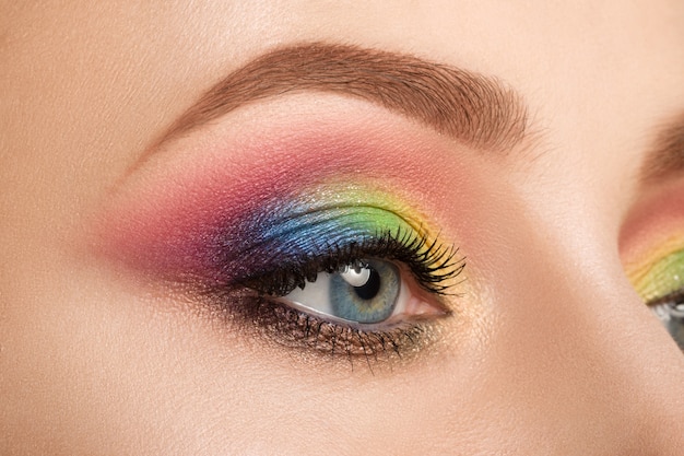 Foto close-up de um olho feminino azul com uma bela e moderna maquiagem criativa