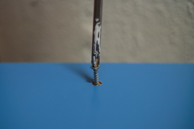 Foto close-up de um parafuso na mesa azul