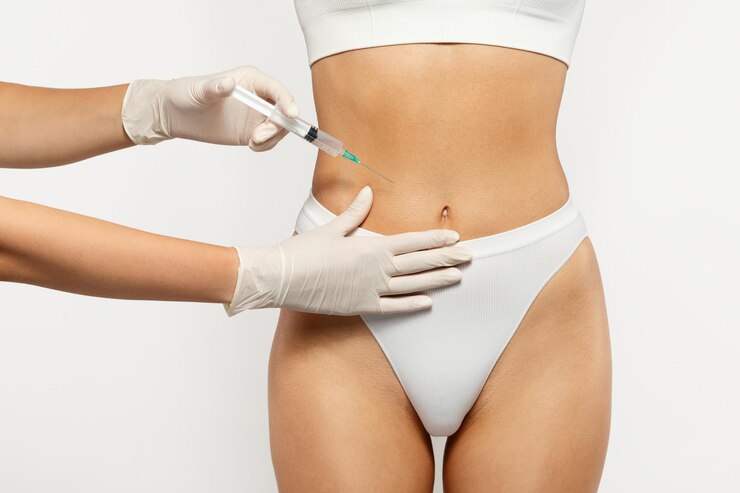 Foto close-up de um profissional de saúde com luvas administrando uma injeção na barriga
