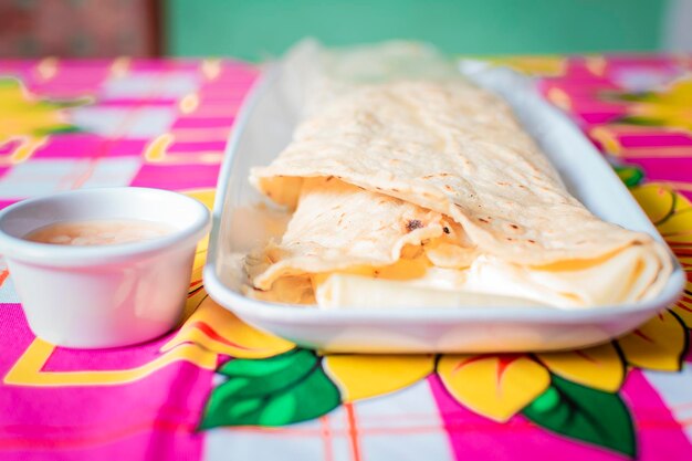 Close-up de um quesillo nicaraguense servido na mesa de madeira Vista superior do quesillo nicaraguense em um prato servido na mesa de madeira Delicioso quesillo nicaraguense tradicional servido na mesa de madeira