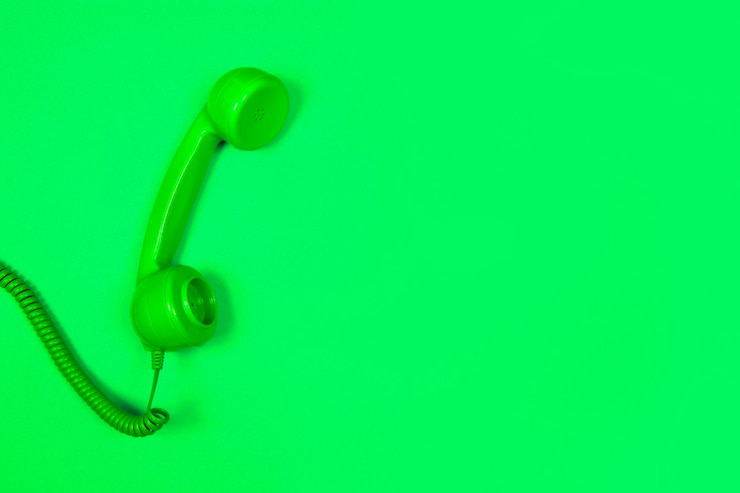 Foto close-up de um receptor de telefone contra fundo verde