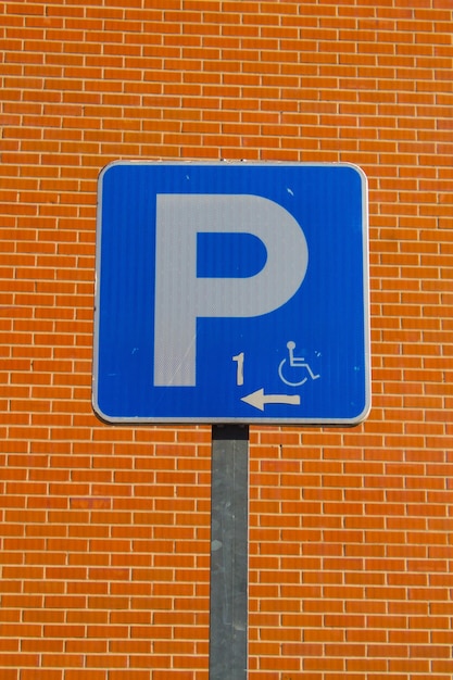Foto close-up de um sinal de estacionamento contra uma parede de tijolos