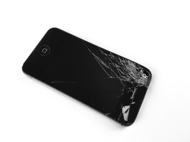 Close-up de um smartphone quebrado em fundo branco