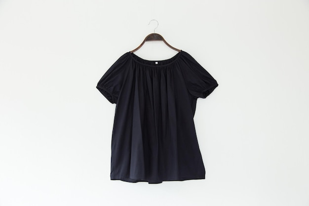 Close-up de um top preto em um gancho contra um fundo branco
