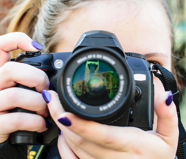 Foto close-up de uma adolescente fotografando com uma câmera