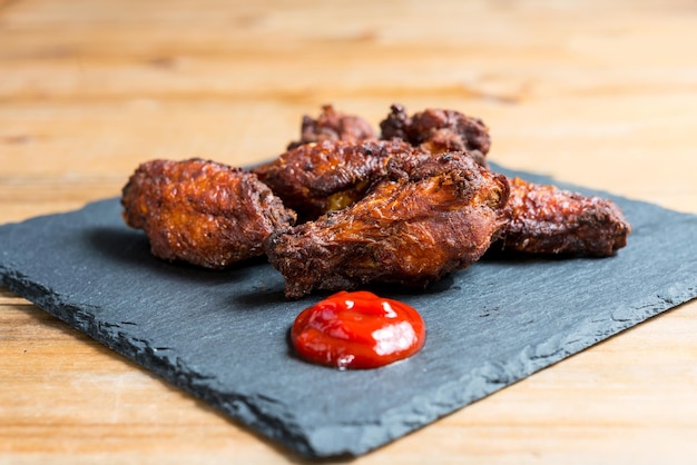 Close-up de uma asa de frango na tábua de cortar sobre a mesa