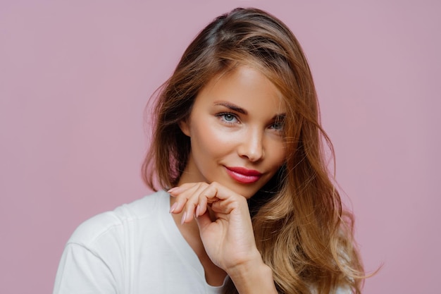 Close-up de uma bela mulher contra um fundo rosa