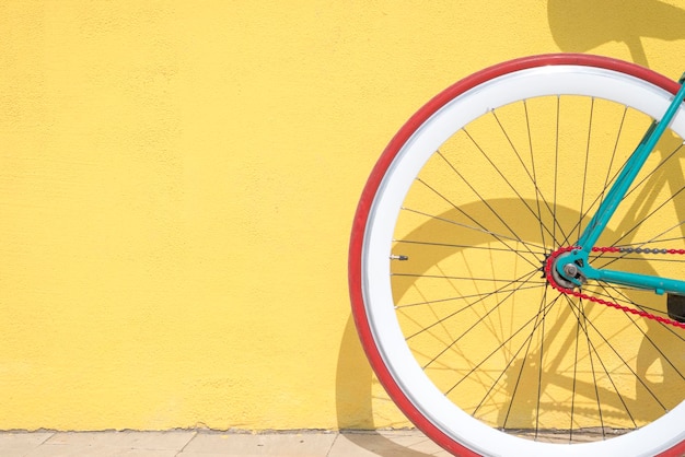 Close-up de uma bicicleta estacionada junto à parede amarela
