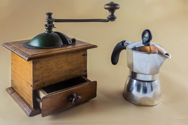 Foto close-up de uma cafeteira e um moedor de café em fundo bege