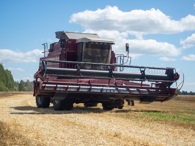 Close-up de uma colheitadeira vermelha passando por um campo para a colheita. Conceito de agricultura