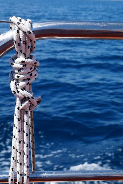 Foto close-up de uma corda amarrada a um barco a navegar no mar