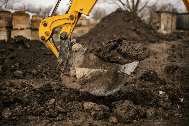 Close-up de uma escavadeira cavando fundação no canteiro de obras