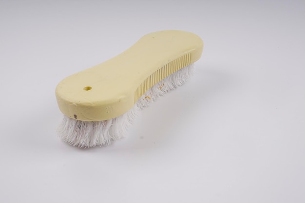 Foto close-up de uma escova de limpeza em fundo cinzento