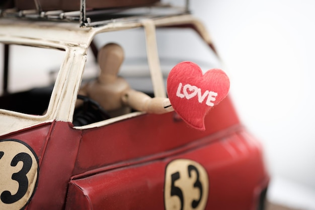 Foto close-up de uma estatueta em forma de coração em um carro de brinquedo