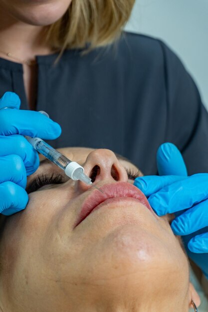 Close-up de uma esteticista injetando botox nos lábios de uma mulher mais velha